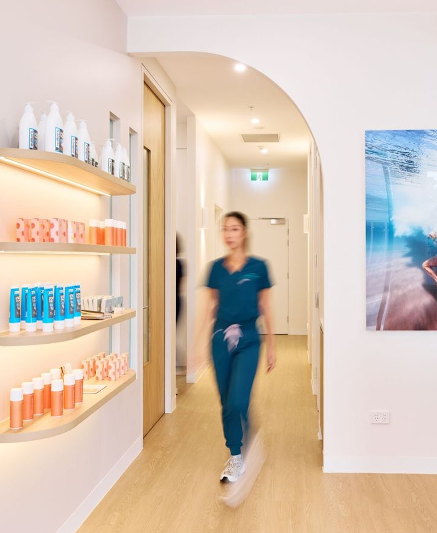 Clinician walking through a modern wellness clinic lined with product shelves